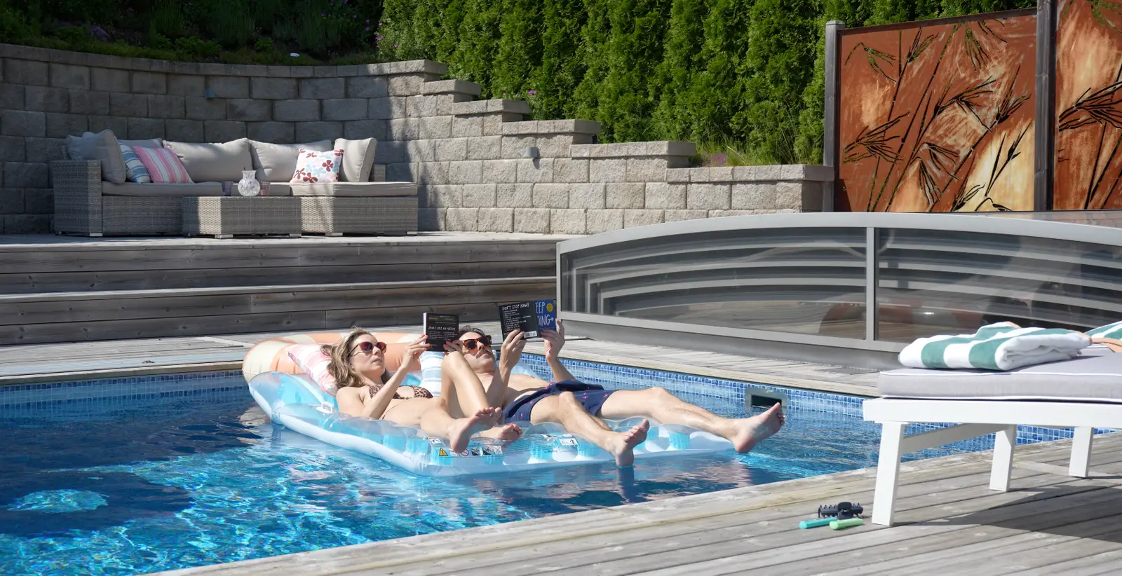Erika and Martin reading their own books on a pool mattress