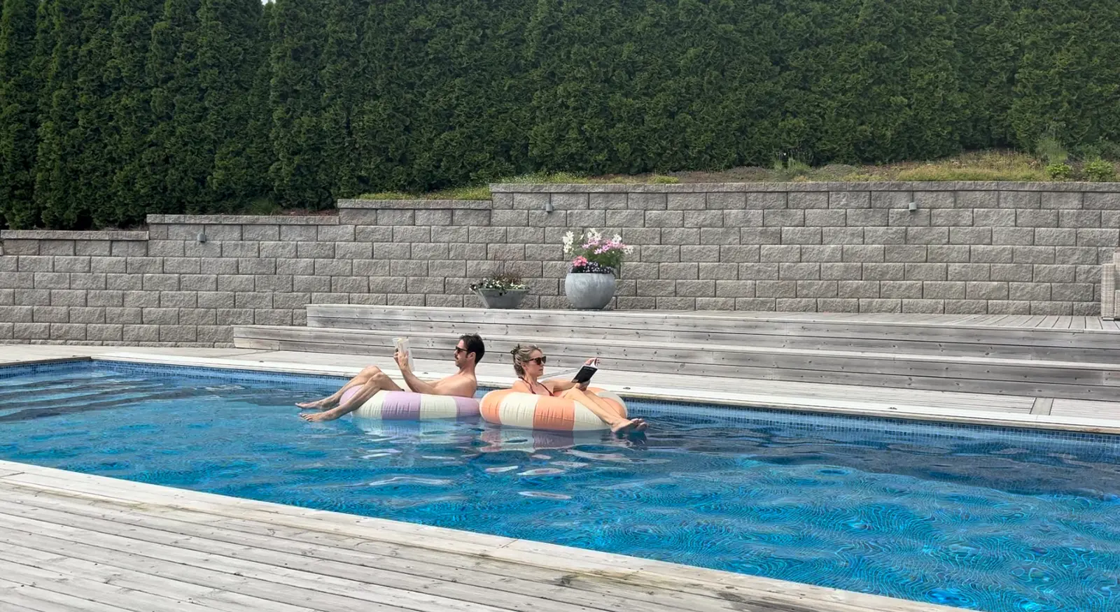 Erika and Martin reading in swim rings in the middle of the pool